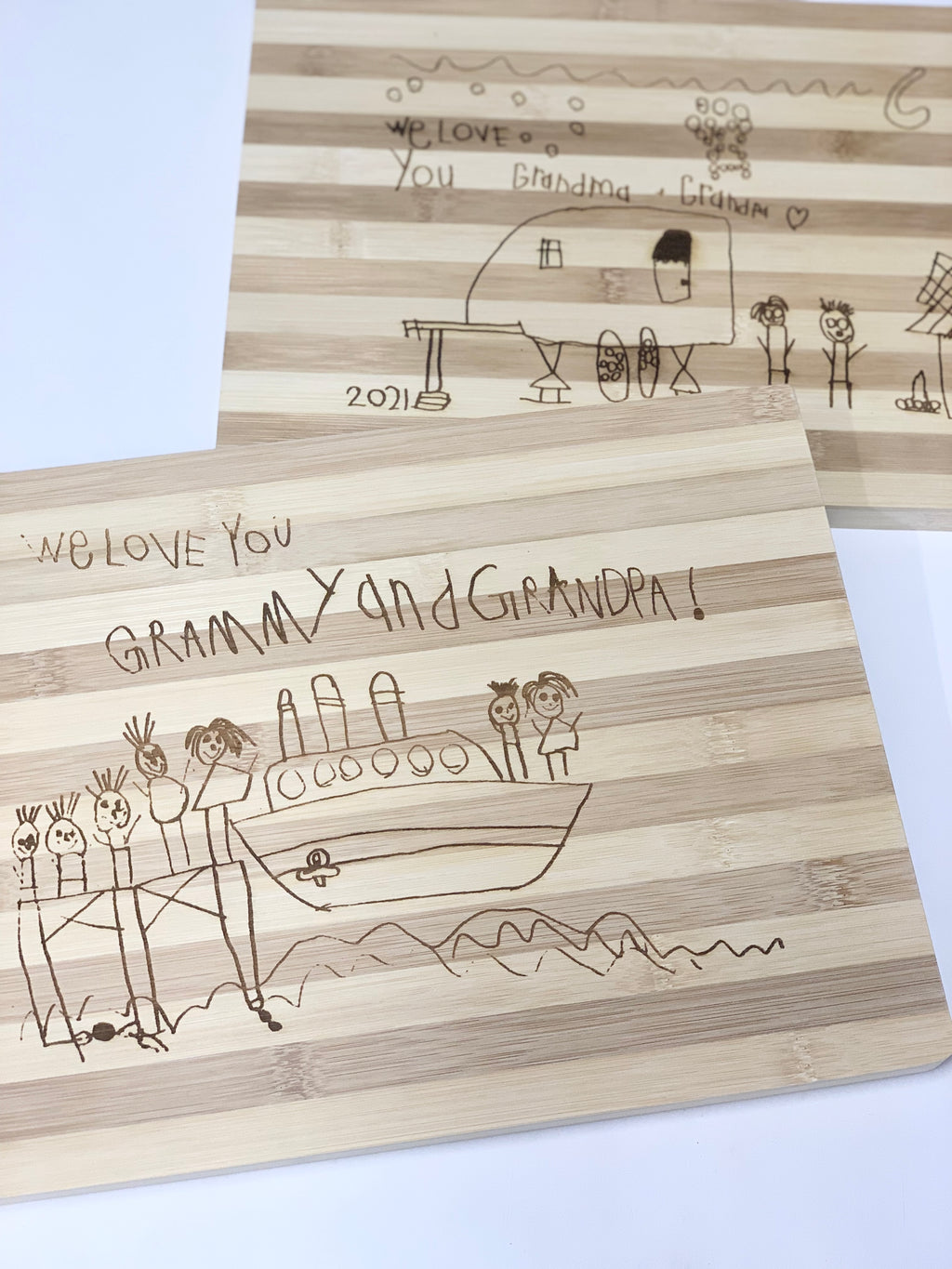 Personalized bamboo cutting board with childlike engraved drawing and "We love you Grammy and Grandpa" text design