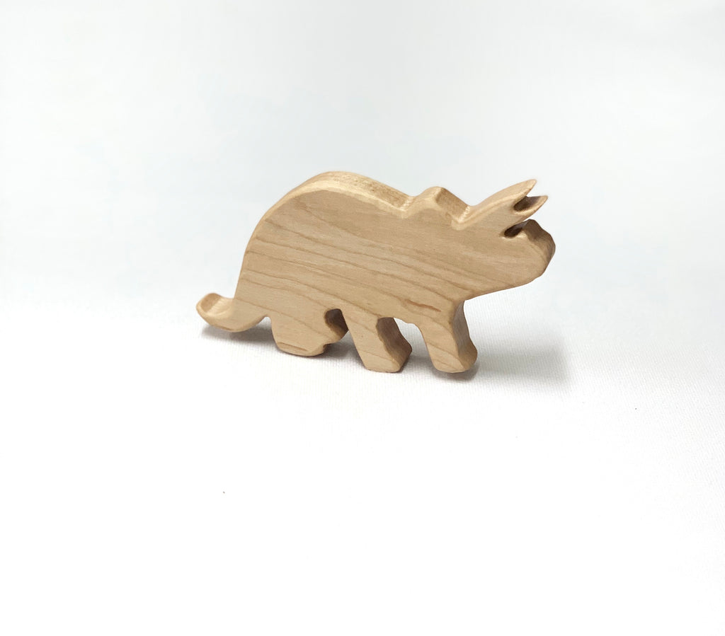 Natural wooden triceratops dinosaur toy figurine with smooth edges on white background for imaginative play