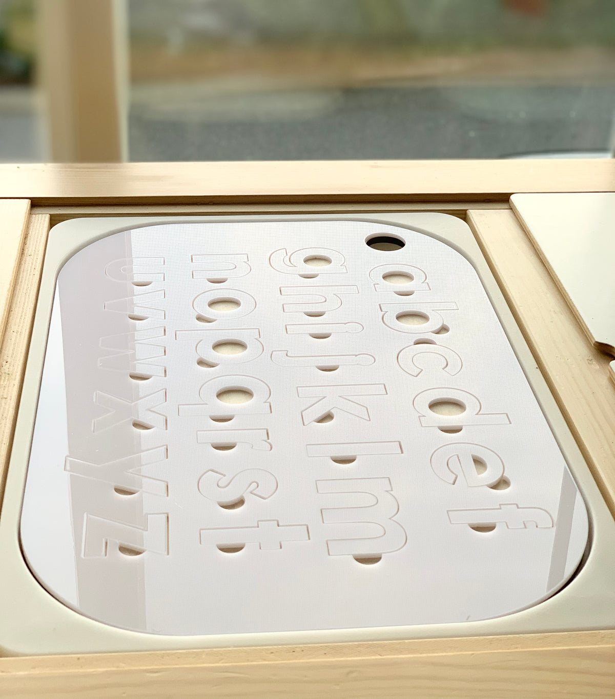 White acrylic lowercase alphabet puzzle insert with maple plywood base fitting Flisat table top with smooth rounded edges