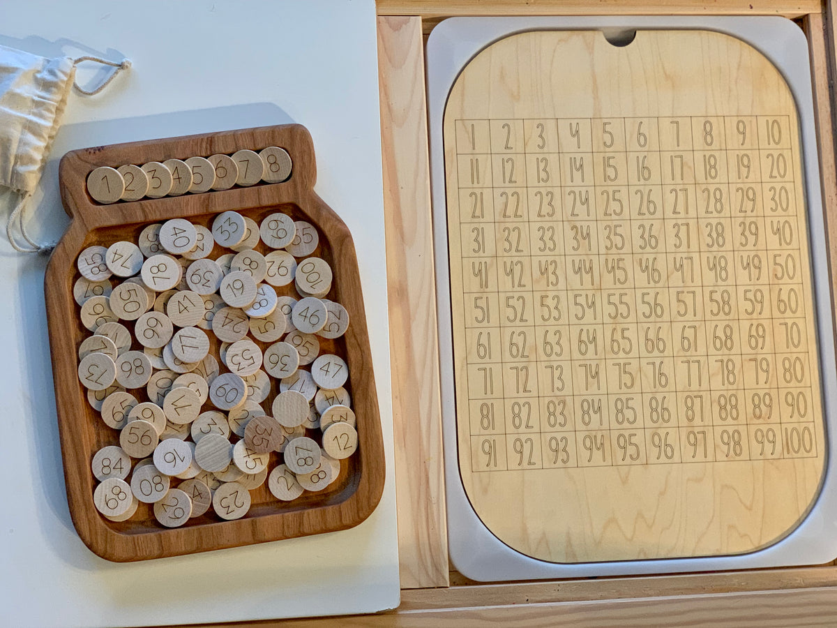 Maple wood 100 hundred frame board with numbered wooden discs next to clear dry erase acrylic insert in wooden tray