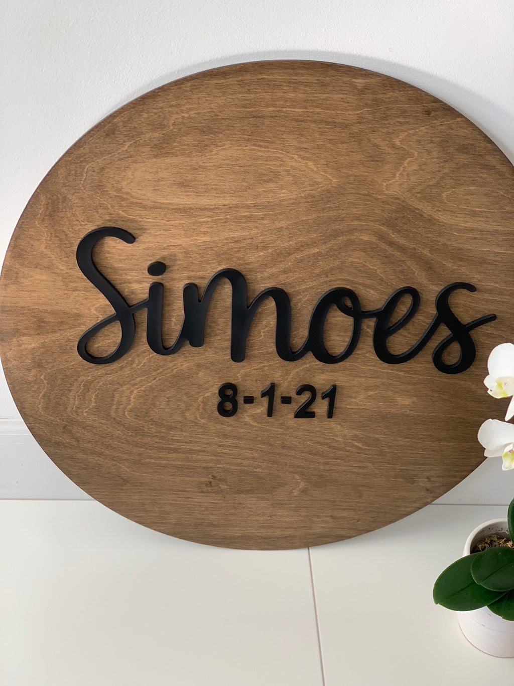 Round wooden guest book alternative sign with black 3D cursive last name and date on natural wood background