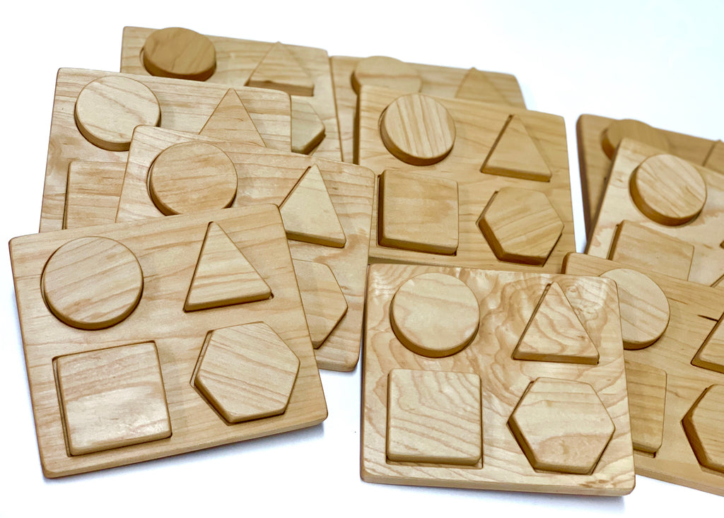 Multiple natural wooden shape puzzles with circle, triangle, square, and hexagon pieces on white background