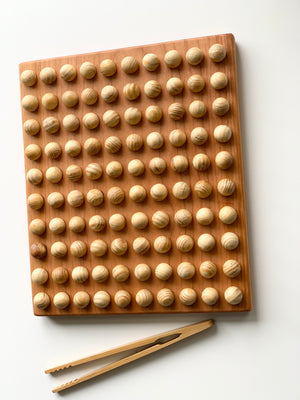 Wooden 100 frame hundred sorting board tray with smooth round balls and wooden tweezers on white background