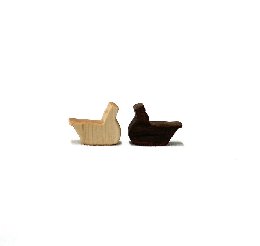 Two small wooden farm animal toy figurines in natural and dark wood tones on white background