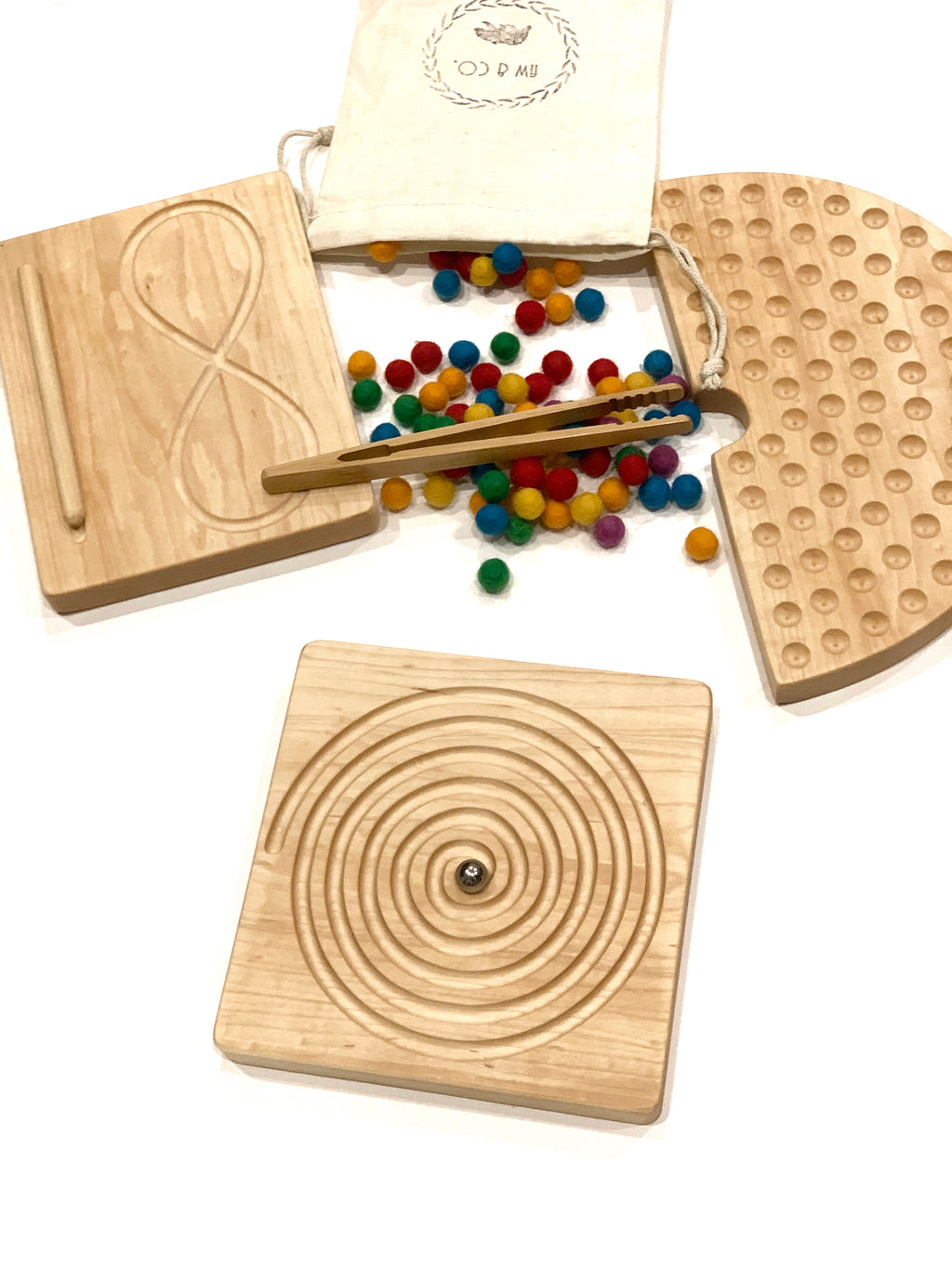 Natural maple hardwood tracing boards with spiral and figure-eight grooves, small colorful felt balls, and wooden tweezers on white background