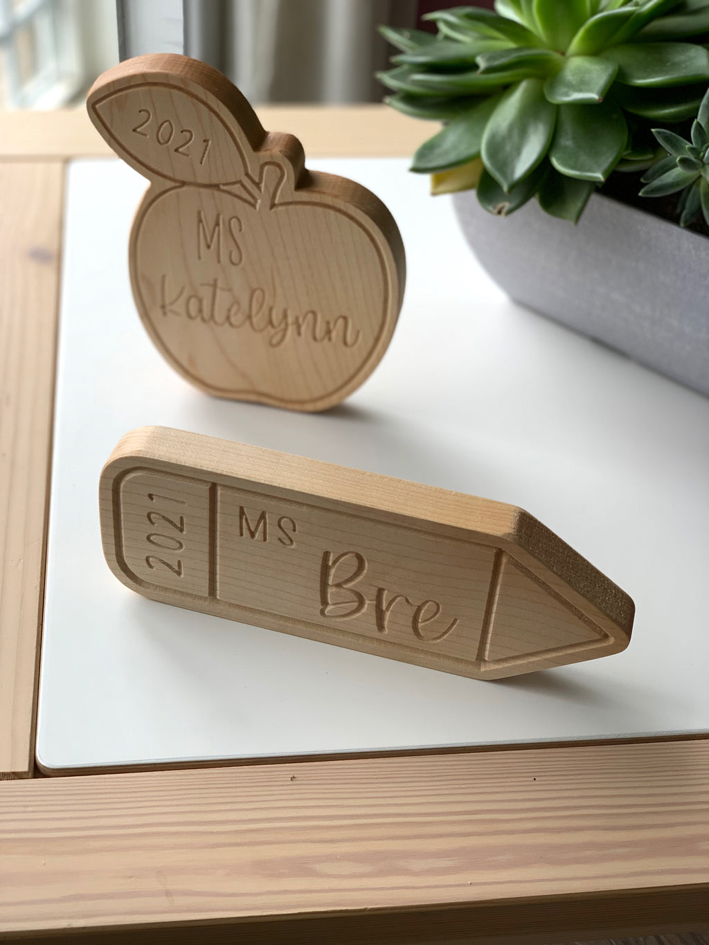 Personalized wooden teacher name plates shaped like an apple and pencil with engraved names and year 2021