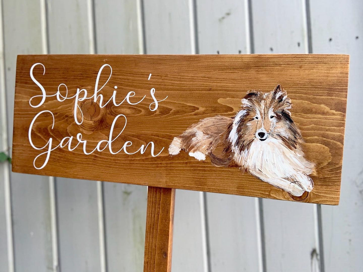 Large custom wooden garden sign with white cursive letters and painted dog illustration on natural wood background