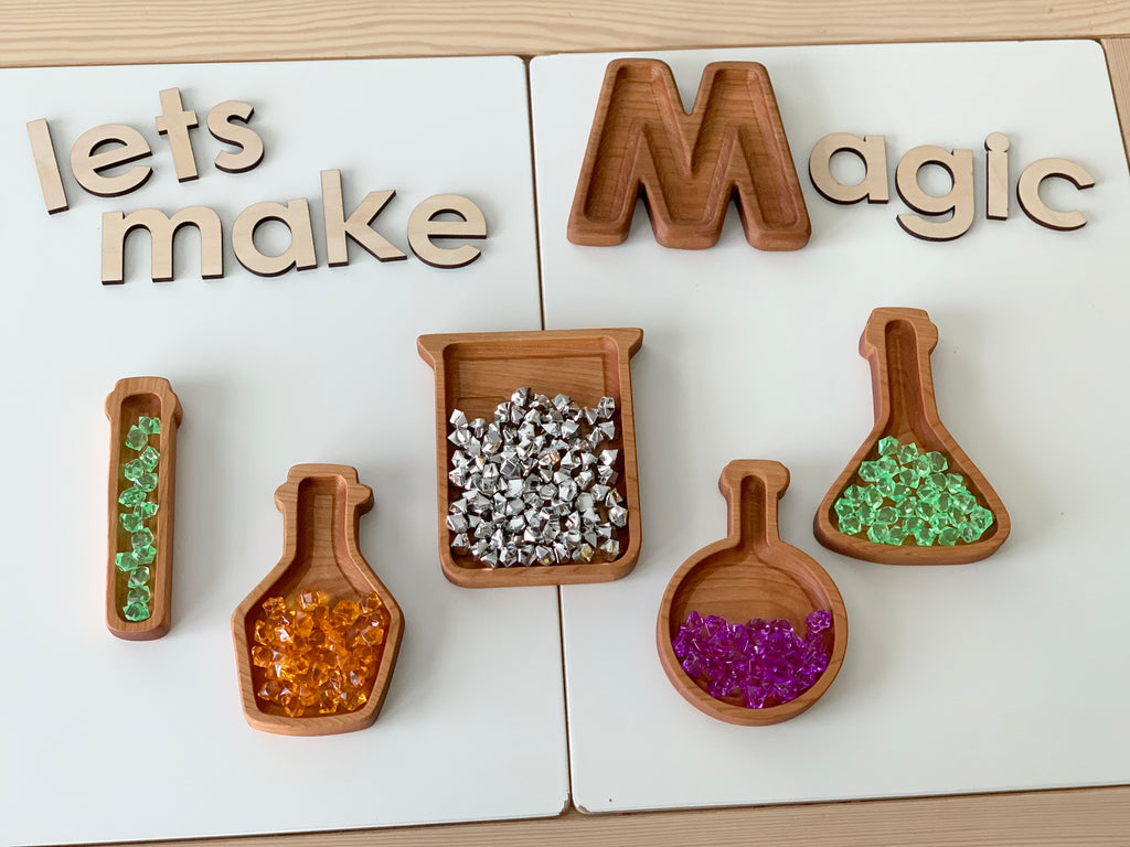 Wooden potion bottle plates shaped like science beakers filled with colorful translucent gems on white background