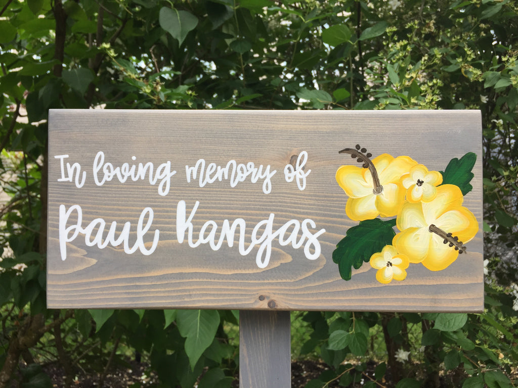 Large personalized wooden garden memorial sign with white cursive lettering and yellow floral illustration on gray wood background