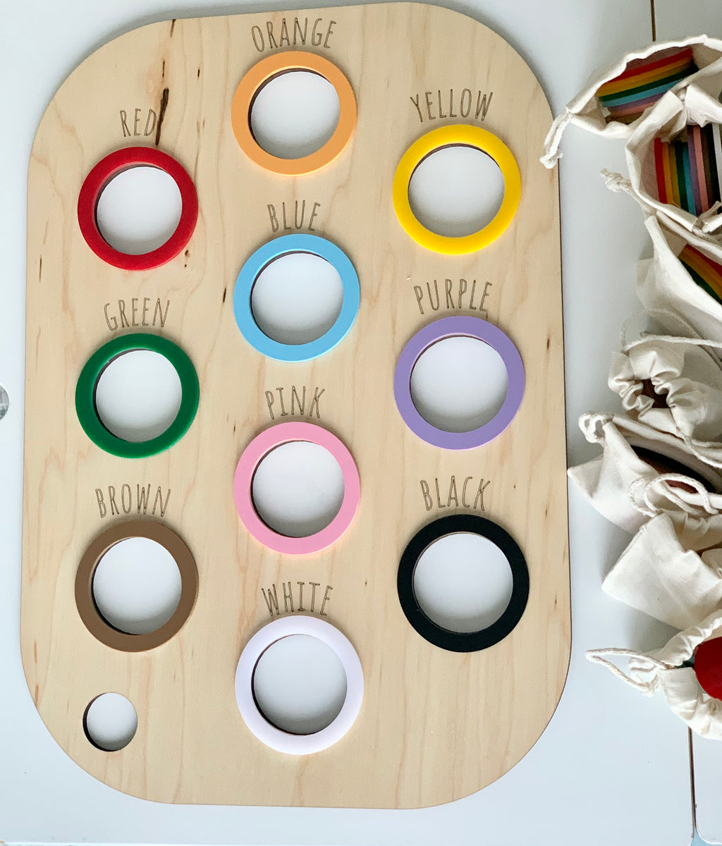 Maple plywood colour sorting table lid with ten circular cutouts and colored rings labeled with color names on light wood background