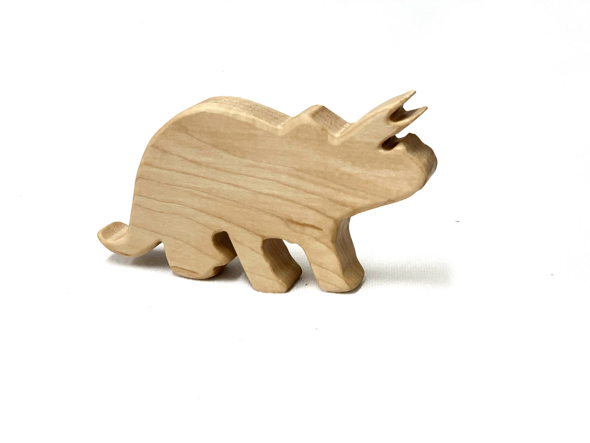 Small natural wooden Triceratops dinosaur toy figurine with smooth edges on white background