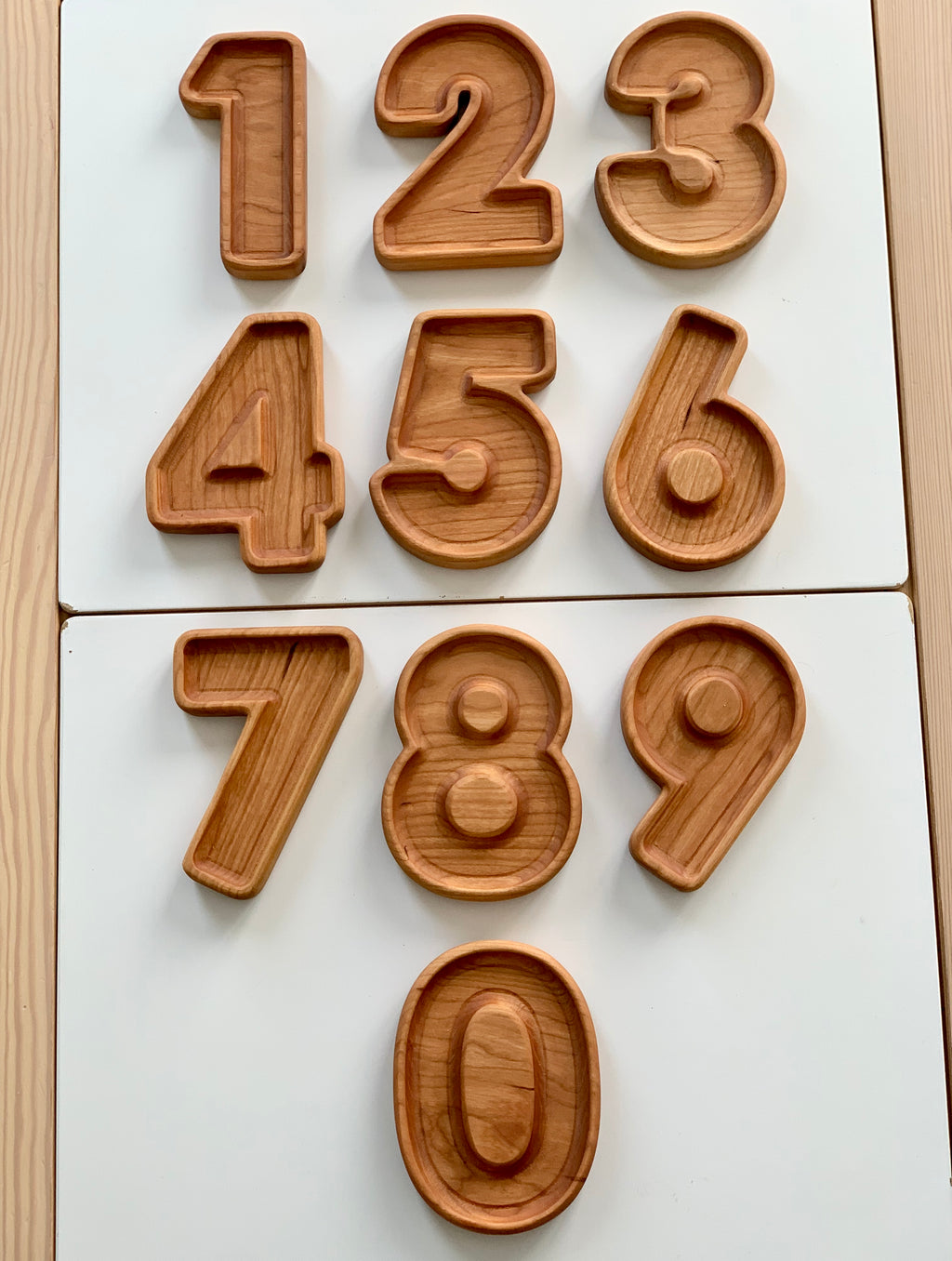Natural wooden number plate sensory trays shaped as digits 1 through 9 and 0 on white background