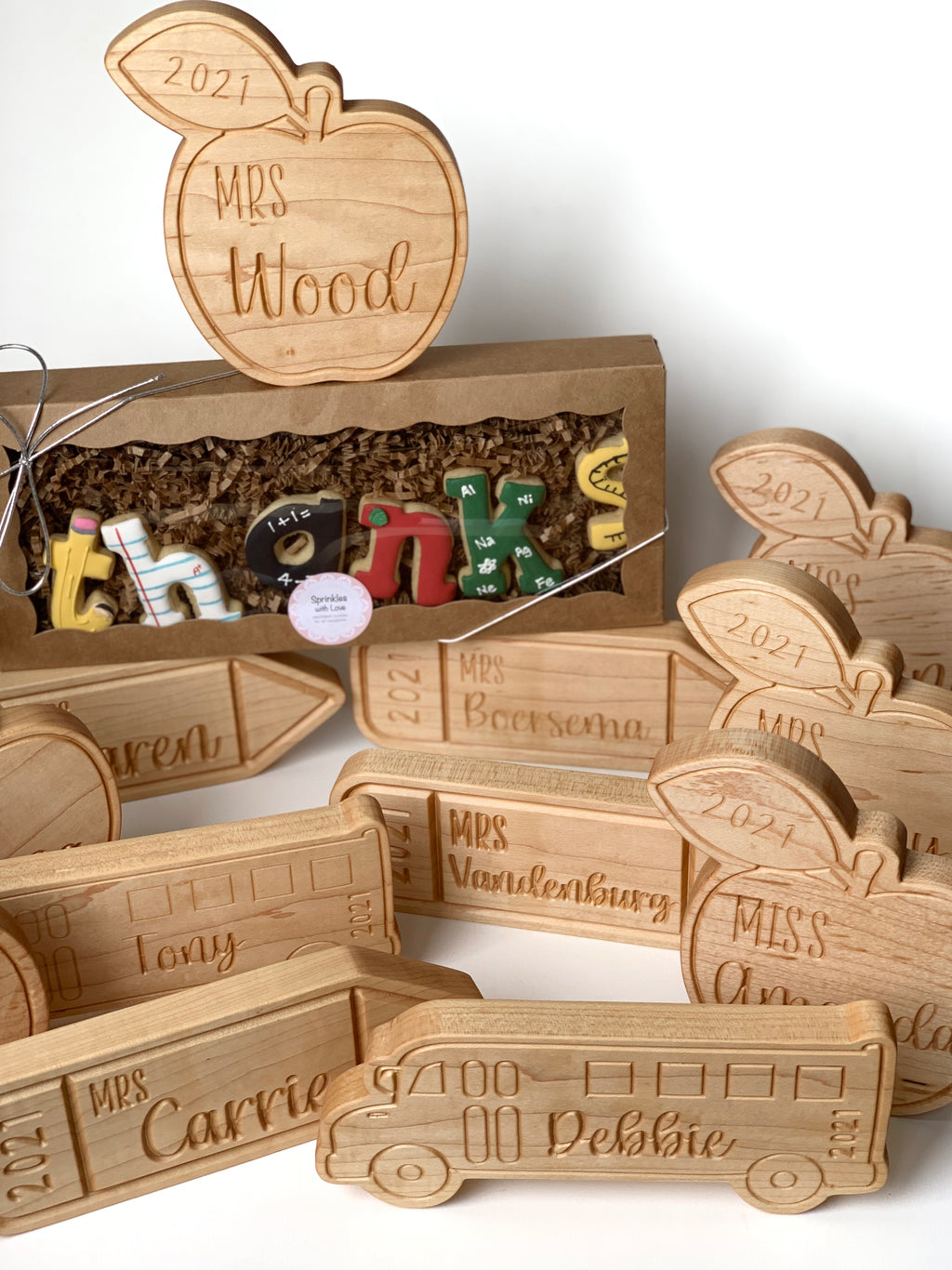 Personalized wooden teacher name plates shaped like apples and school buses with engraved names and year 2021