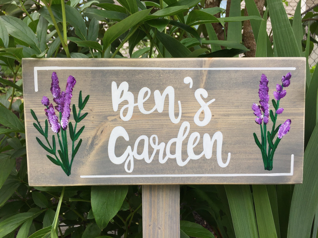 Large custom wooden garden sign with white cursive letters and purple floral illustrations on natural wood background
