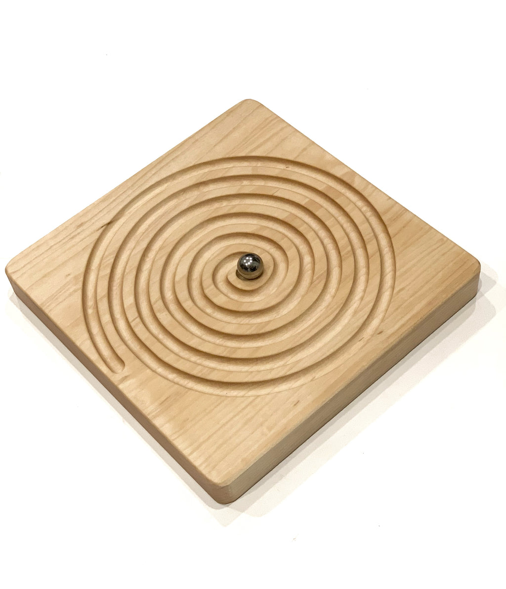 Square Canadian maple hardwood labyrinth tracing board with concentric engraved swirly grooves and metal ball on white background