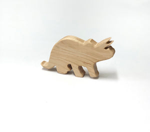 Small natural wooden Triceratops dinosaur toy figurine with smooth edges on white background