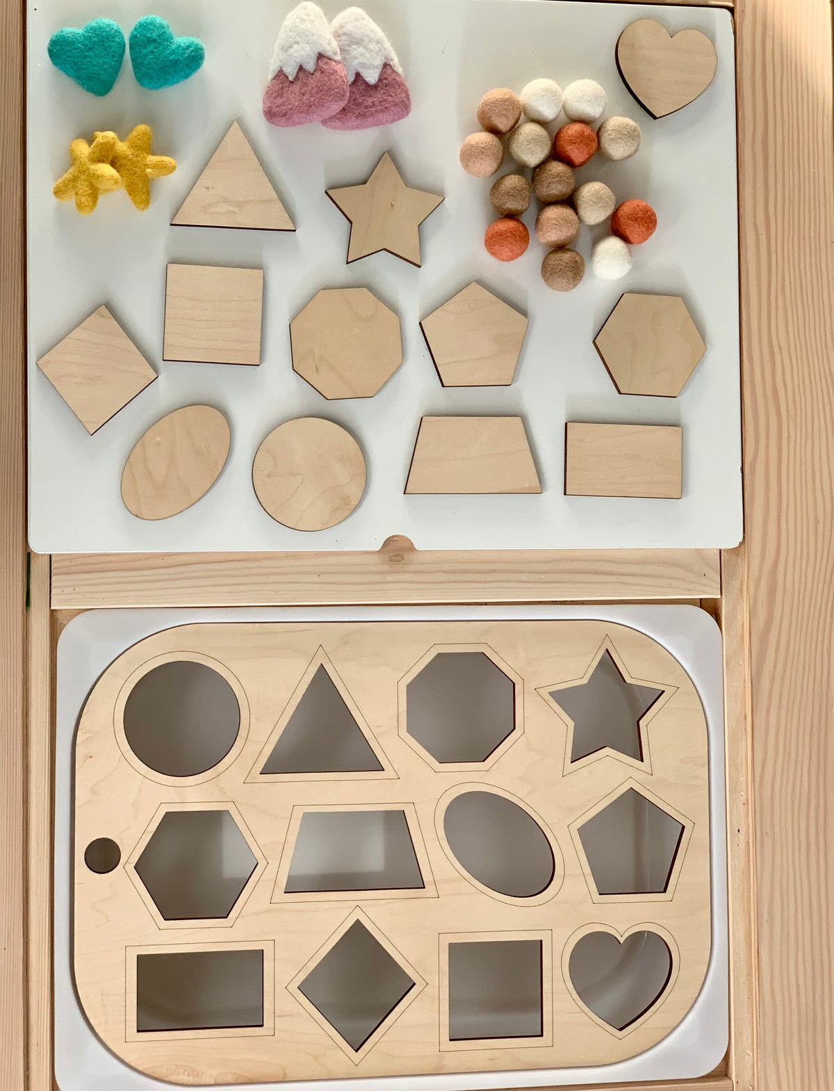 Wooden shape sorter Flisat table top insert with geometric shapes and colorful felt balls on wooden surface