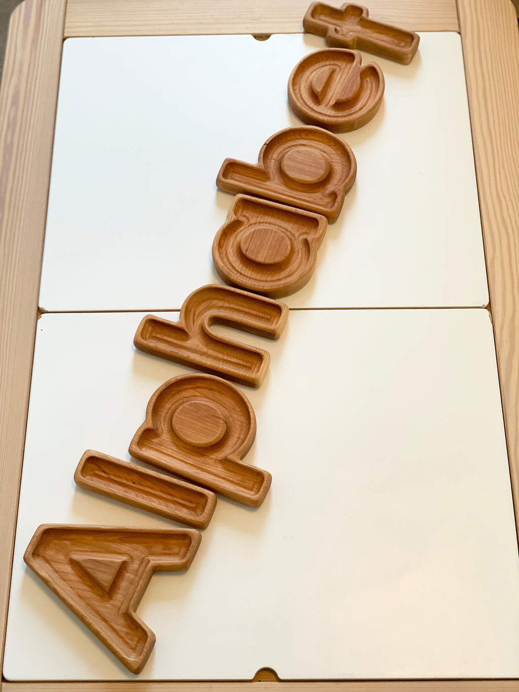 Wooden alphabet letter sensory trays spelling word Alphabet on natural wood background